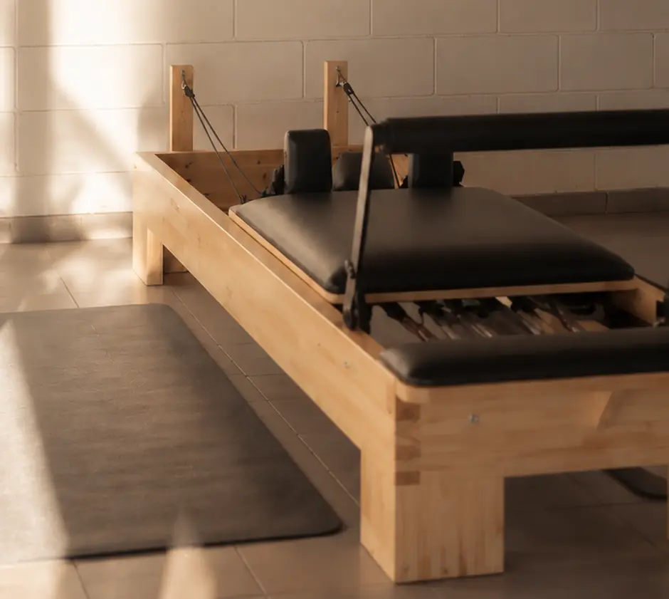 Reformer junto a la pared de ladrillo blanco con sombras de luz natural